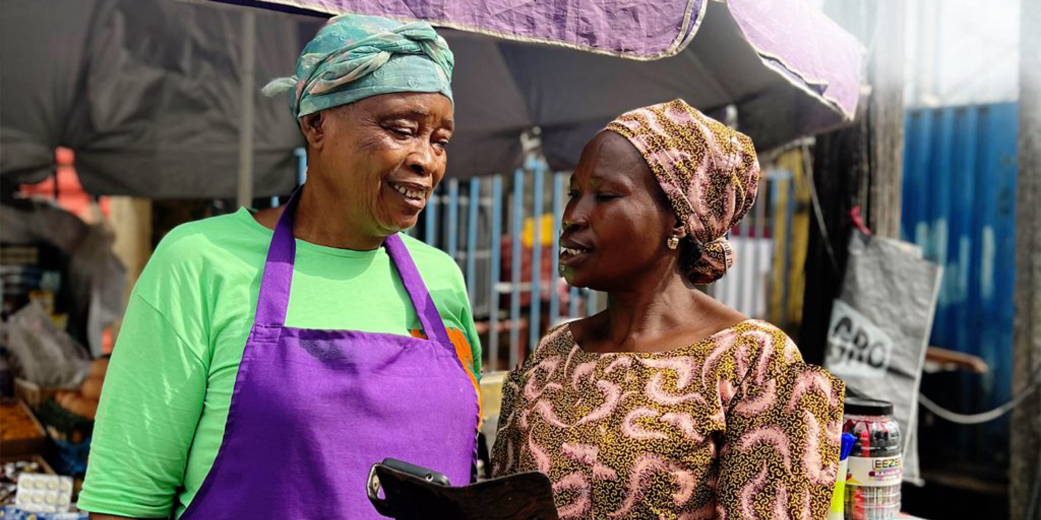 Two older women standing together, beneficiaries of Moni’s business loan 