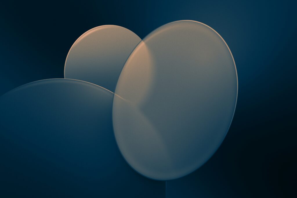 Three translucent overlapping circles in warm gold and cool teal tones against a dark blue background.