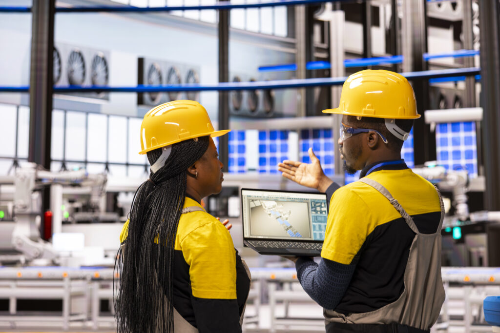 Black engineers supervising industrial automation systems.